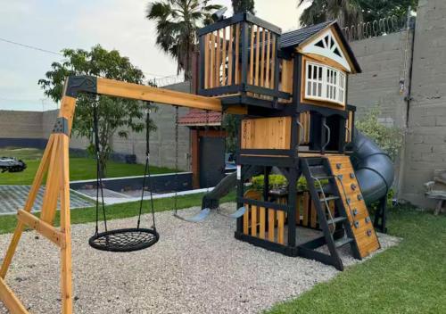 a playground with a tree house and a swing at Casa Ohana Morelos in Tlayacapan