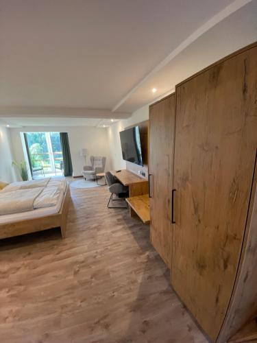 a bedroom with a bed and a large wooden cabinet at Rhön-Hotel Sonnenhof - in Poppenhausen