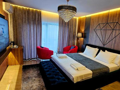 a hotel room with a bed and two red chairs at Hotel Diamant in Tropojë