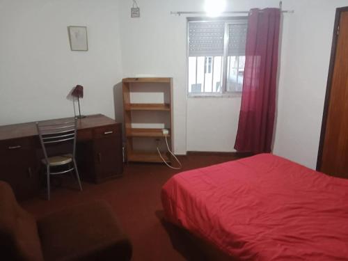 a bedroom with a bed and a desk and a chair at apartamento com varios quartos in Coimbra