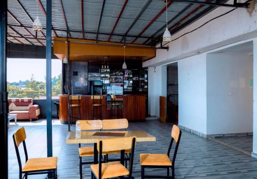 a table and chairs in a room with a bar at Global Village Apartment in Kigali