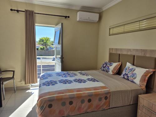 a bedroom with a bed and a door to a balcony at Pemba's residence in Cape Town