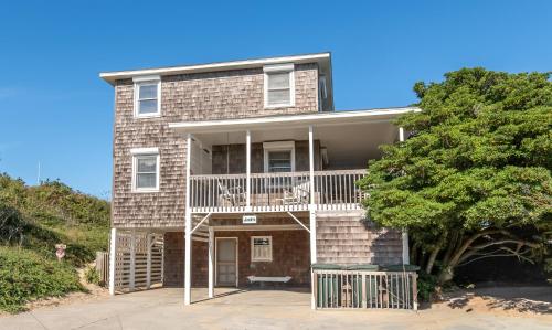 a brick house with a balcony and a tree at Jacks - Nags Head MP 12, Oceanfront, Ocean Views, Huge Deck, YMCA Pkg in Nags Head
