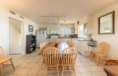 a kitchen with a wooden table and chairs at Jacks - Nags Head MP 12, Oceanfront, Ocean Views, Huge Deck, YMCA Pkg in Nags Head