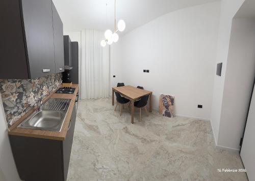 a kitchen with a table and a sink and a table and chairs at B&B Domus morfeo Caserta in Caserta