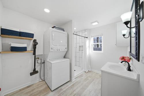 a white bathroom with a sink and a washing machine at Deep Water Stays on Lake Murray in Lake Murray Shores