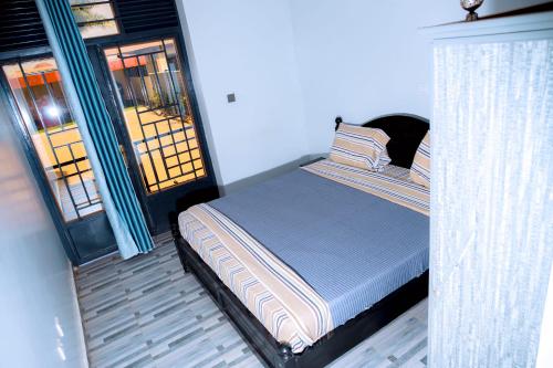 a bedroom with a bed and a door with a window at Global Village Apartment in Kigali