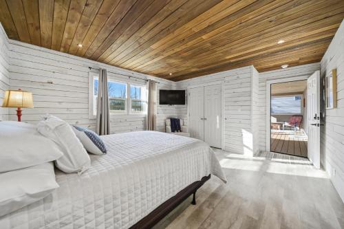 a bedroom with a white bed and a wooden ceiling at Deep Water Stays on Lake Murray in Lake Murray Shores