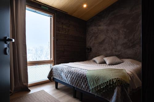 a bedroom with a bed and a large window at Villa Light in Ruka