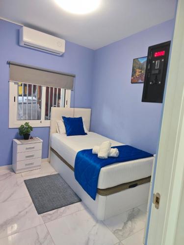 a bedroom with a bed with blue walls at Relax House Barcelone in Sant Esteve Sesrovires