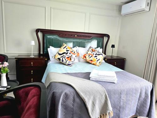 a bedroom with a large bed with pillows on it at Charming Studio in Golden Triangle in Harare