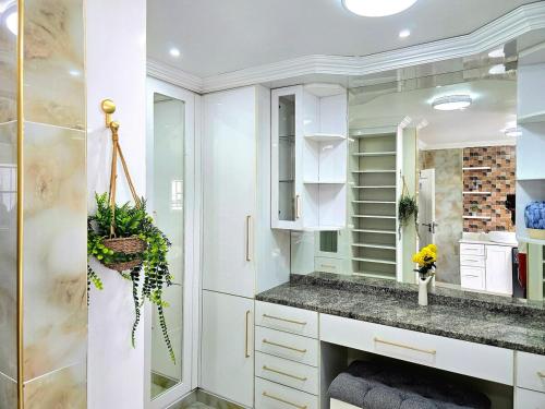 a white bathroom with a sink and a shower at Charming Studio in Golden Triangle in Harare