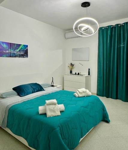 a bedroom with a large bed with blue sheets at Armonia dell'Etna in Santa Venerina