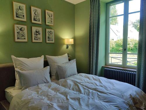 a bedroom with a bed with white sheets and a window at BellevueBretagne - Chambres d'Hôtes in Saint-Jean-du-Doigt
