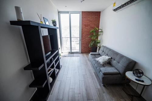 a living room with a couch and a book shelf at Centro Cuauhtémoc Departamento en el Corazon de Monterrey in Monterrey