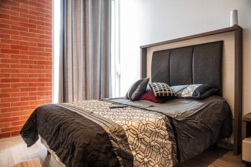 a bedroom with a large bed with pillows on it at Centro Cuauhtémoc Departamento en el Corazon de Monterrey in Monterrey