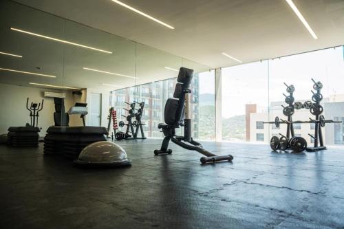 a gym with exercise equipment in a room with a window at Centro Cuauhtémoc Departamento en el Corazon de Monterrey in Monterrey