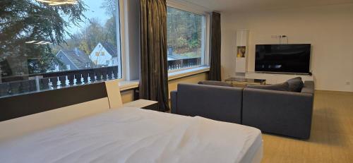 a room with a bed and a tv and a couch at Luxury View in Westerburg
