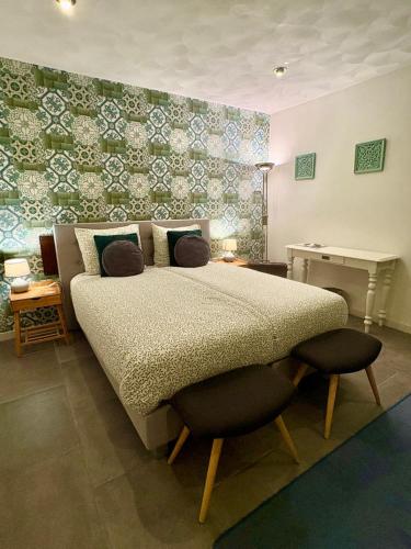 a bedroom with a large bed with a chair and a wall at Gasterij Hotel Dennenoord in Boxtel
