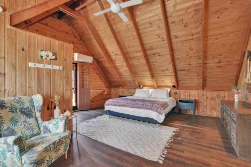 a bedroom with a bed and a chair in a room at Aloha Amity in Amity Point