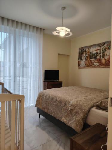 a bedroom with a bed and a tv and a window at Holiday Home Varese- Family & Group stay with private parking in Varese
