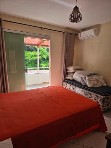 ein Schlafzimmer mit einem großen roten Bett und einem Fenster in der Unterkunft kibeleza in Ilhéus