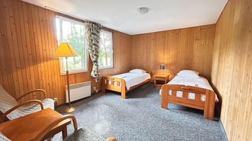 a bedroom with two beds and a table and chairs at Hotel Pod Sosnami in Osieck