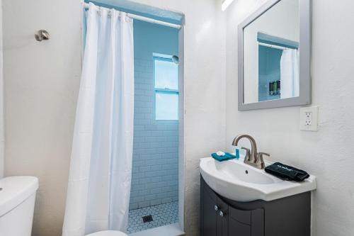 a white bathroom with a sink and a shower at Teal Tropical Villa in Largo