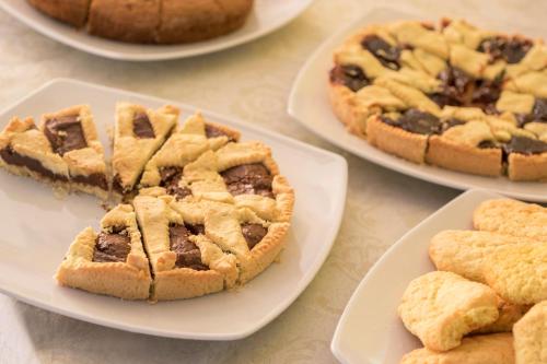 a table topped with plates of pies and cookies at Hotel Mignon Riccione Fronte Mare in Riccione
