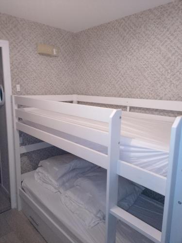 białe łóżko piętrowe w małym pokoju w obiekcie La BRIGANTINE 3 w mieście Fort-Mahon-Plage
