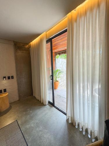 a room with a sliding glass door with a plant at Makena Hotel in Icaraí