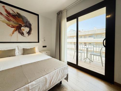 a bedroom with a bed and a large window at Emerald Sun Hotel in Cambrils