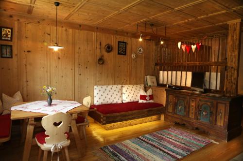 a living room with a table and a couch and a table and chairs at Bauernhof im Wiesengrund in Maria Luggau