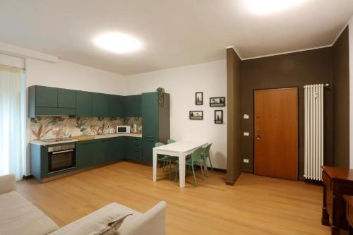 a kitchen with green cabinets and a white table at Solferino Green - Modern Stay - Near station in Brescia