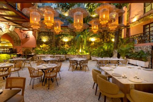 a restaurant with tables and chairs and plants at El Marques Hotel Boutique By GEH Suites in Cartagena de Indias