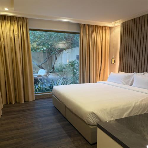 a bedroom with a large bed and a large window at Ramla Resort in Riyadh