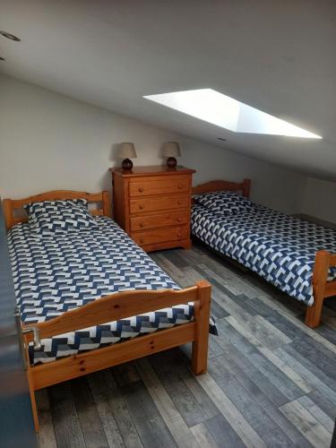 a bedroom with two beds and a skylight at Maison agréable à Oléron in Dolus-d'Oléron