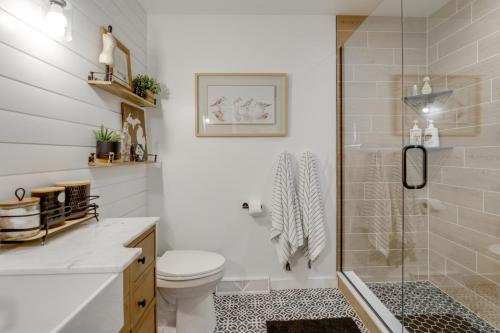 a bathroom with a toilet and a glass shower at Deck, Fire Pit! Fully Updated Home Near Lake Huron in Caseville