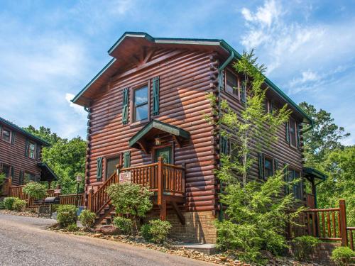 a log house with a porch and a deck at Celebration Lodge in Gatlinburg