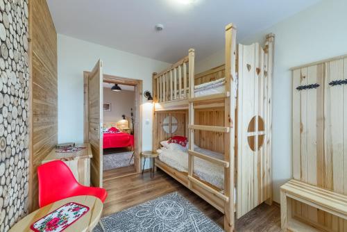 a room with two bunk beds and a red chair at Willa Roztoka & SPA - idealne miejsce dla Twojej rodziny in Bukowina Tatrzańska