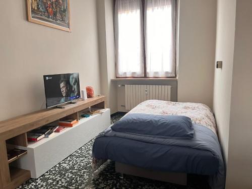 a bedroom with a bed and a television in it at La porta sul Viale in Cuneo
