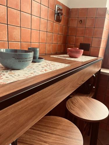 a counter with two bowls and two stools at La porta sul Viale in Cuneo