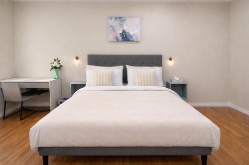 a bedroom with a large white bed and a desk at Vita House - Rogers Stadium and Yorkdale Mall Toronto - quiet and cozy bedrooms in Toronto