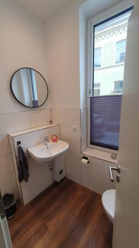 a bathroom with a sink and a mirror and a window at Monteurzimmer 05 in Parchim in Parchim