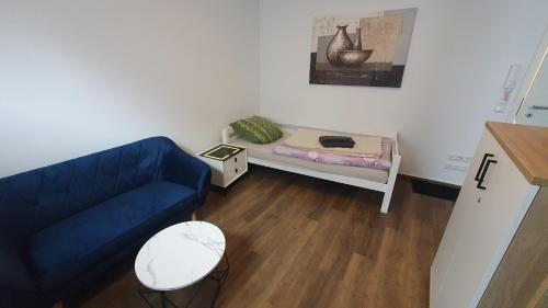 a living room with a blue couch and a small bed at Monteurzimmer 05 in Parchim in Parchim