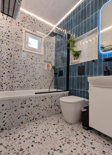 a bathroom with a toilet and a sink and a tub at Beautiful apartment near beach in Larnaca in Scala