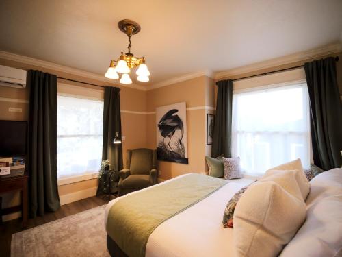 a bedroom with a bed and a chandelier at RedTail Inn - 3 Suites Sleeps up to 12 in Ashland