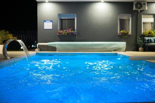 a large blue swimming pool with a water fountain at Villa De Luxe Infinity in Bihać