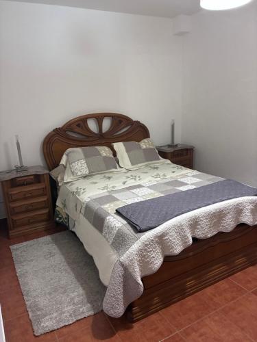 a bedroom with a large bed and two night stands at Rolo House in Nazaré