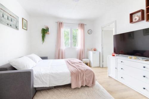 a white bedroom with a bed and a tv at Le Cocoon d'Alfortville - Aux portes de Paris in Alfortville